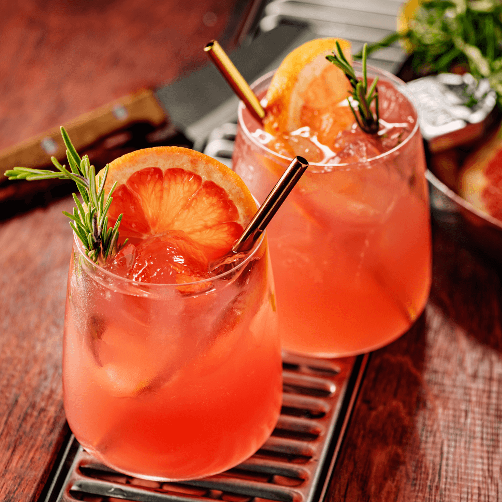 Paloma with red grapefruit juice, lime juice, and agave syrup topped with club soda and garnished with grapefruit slice and rosemary. Perfect mocktail for dry January.