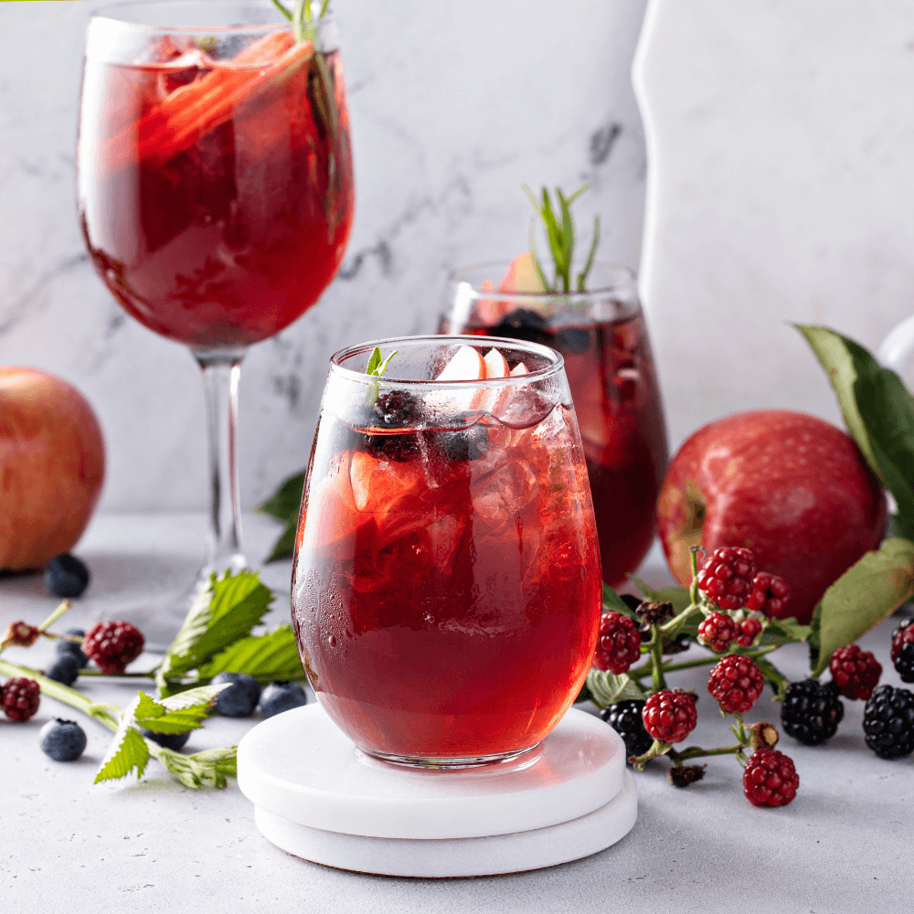 Fall berry and apple sangria in a glass with ice, refreshing fall cocktail or mocktail idea