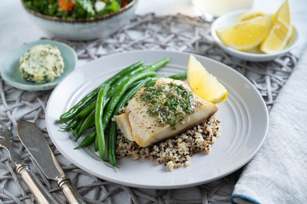 Plate with broiled black code with lemon caper butter, quinoa, and green beans