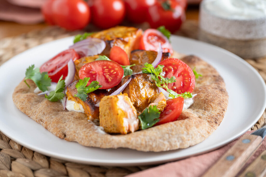 Togurt marinated crispy salmon with sliced tomatoes and fresh cilantro on whole wheat naan