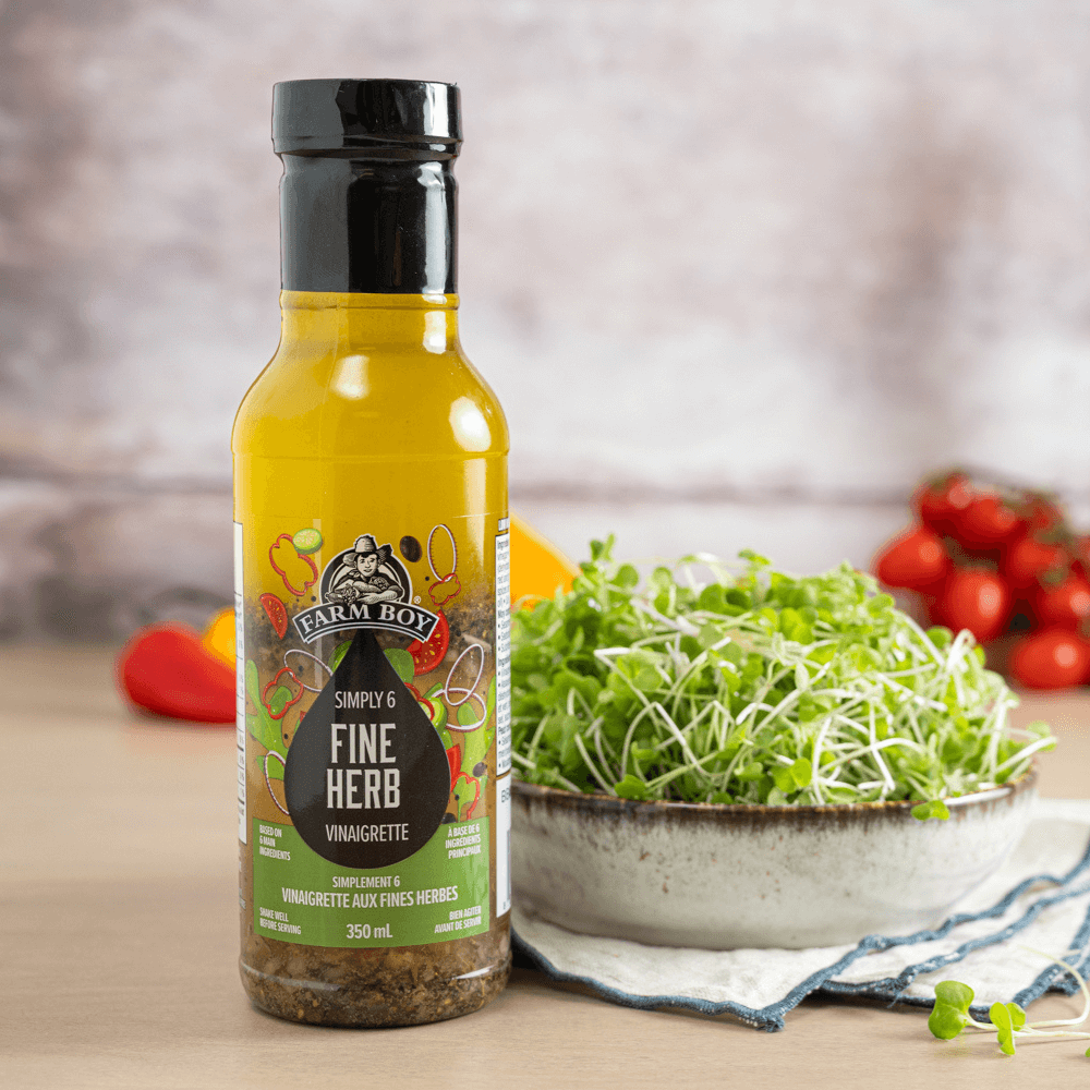 Bowl of microgreens beside a bottle of Farm Boy Simply 6 Fine Herb Vinaigrette